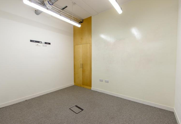 Small private office with white walls and a light wood storage cupboard.