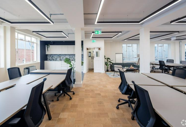 Spacious open-plan workspace at 90-93, Cowcross Street, London with modern lighting and wood-style flooring.
