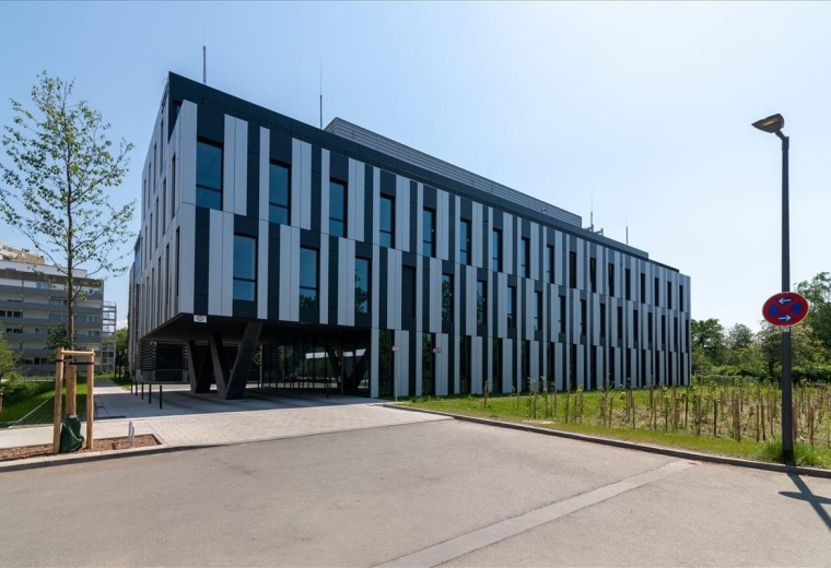 Modern exterior view of the Berliner Straße 300 building with its distinct black and white striped facade.