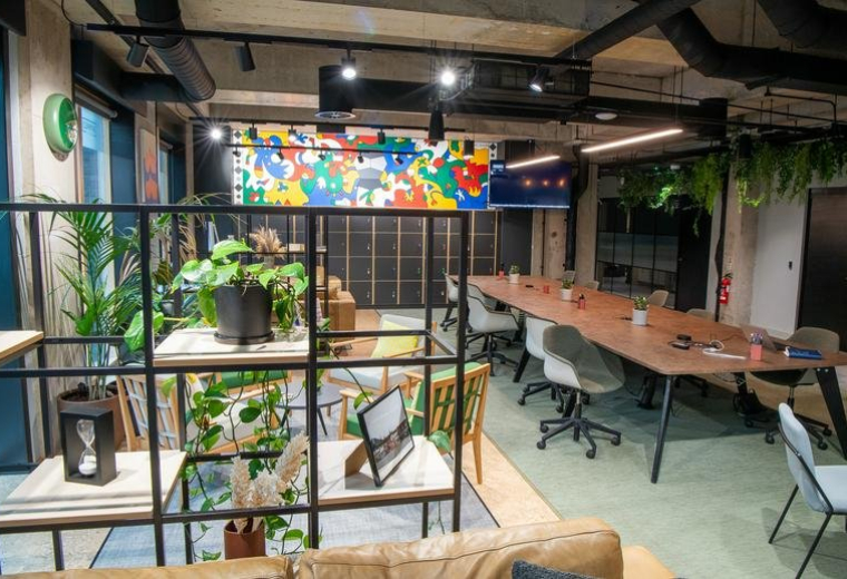 Vibrant coworking space with a mix of desk seating, lounge areas, and a colourful mural.