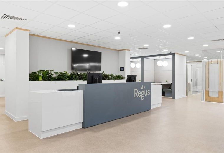 Sleek reception desk at Cromwell House with branded signage and indoor greenery.