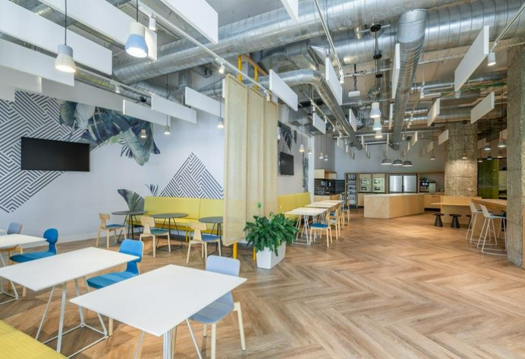 Spacious communal breakout area and cafe at Don Ramón De La Cruz, 84, Madrid with chevron wood floors.