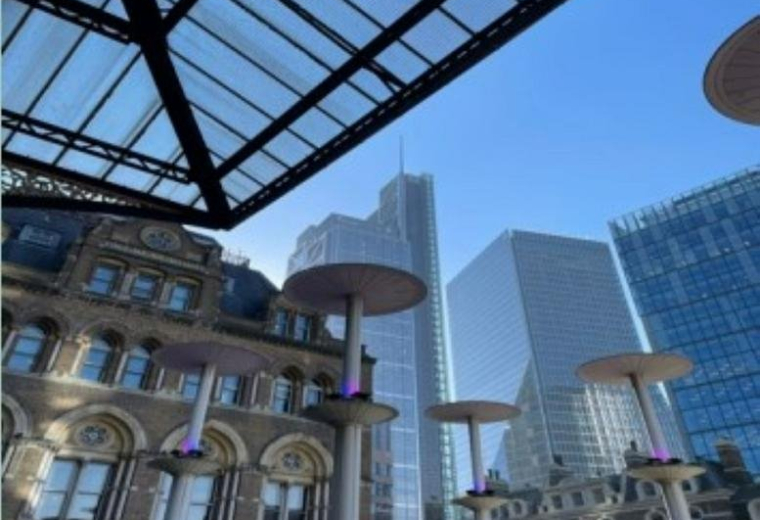 Rooftop terrace featuring modern heat lamps and views of nearby city skyscrapers.