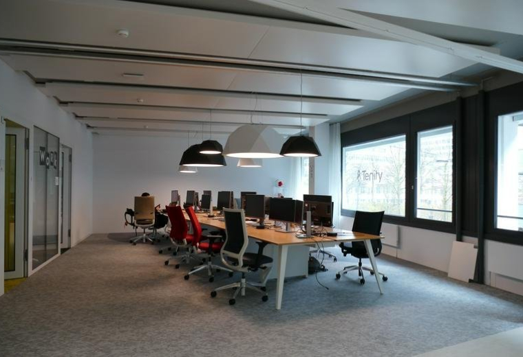 Spacious open-plan workspace at 110, Pfingstweidstrasse with pendant lights and rows of desks.