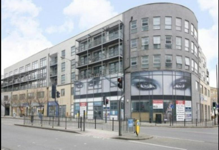 Exterior view of the curved brick facade of 133 Creek Road featuring large graphic eye murals.