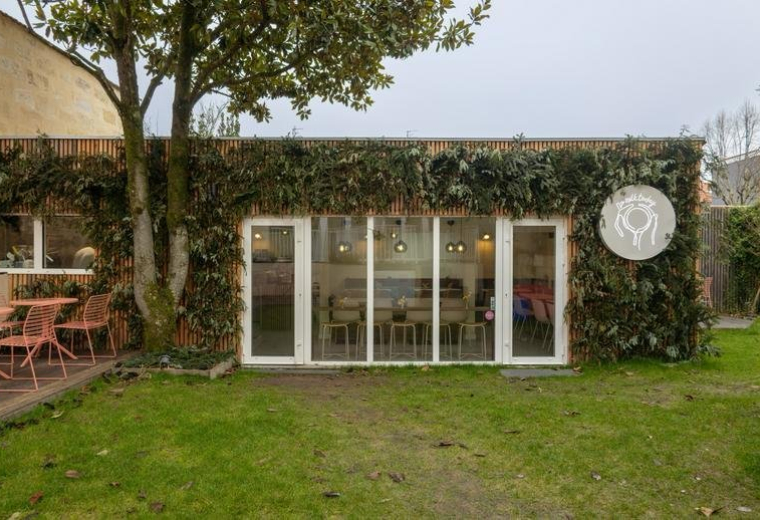 Exterior garden view of the ivy-covered brick building at 155, Rue Turenne.