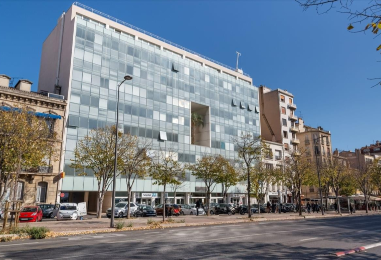 Exterior view of the glass-facade building at 165 Avenue du Prado.