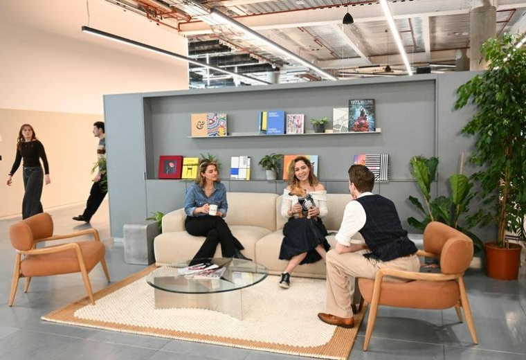 Lounge area with a modern sofa, coffee table, and bookshelves at 191 Wood Lane MediaWorks.