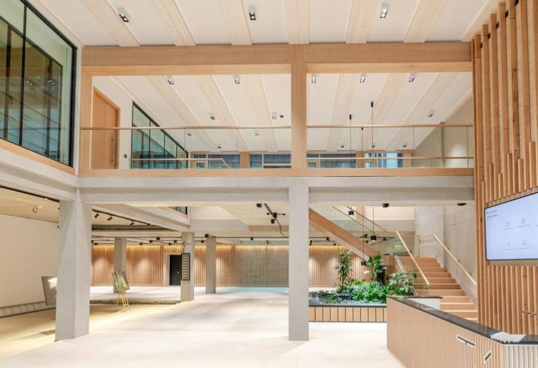 Grand multi-level lobby with wood accents and an indoor garden at 31, Elsenheimerstraße.