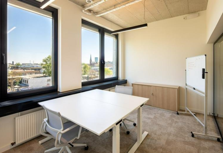 Meeting room with a white standing desk and panoramic city views at 32, Warschauer Straße.