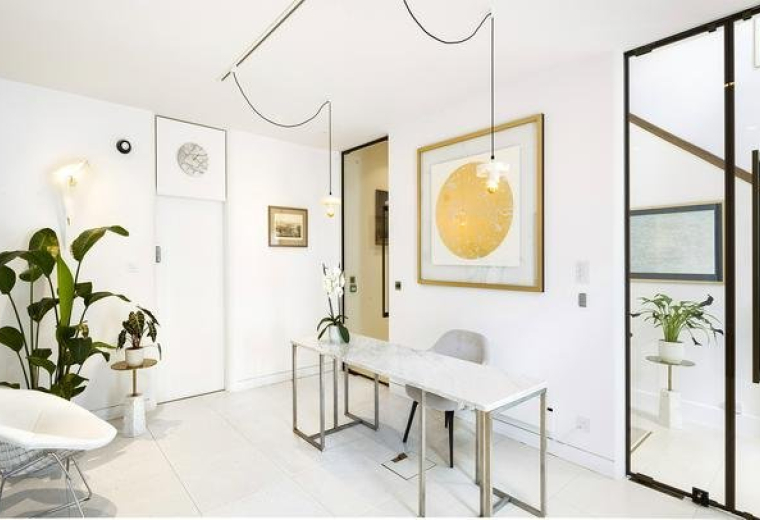 Bright, modern reception area at 338, City Road with stylish white furniture and gold accents.