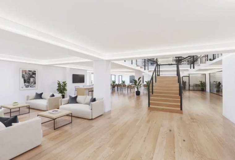 Spacious communal lounge with white sofas and wooden floors at 34, Avenue des Champs-Élysées.