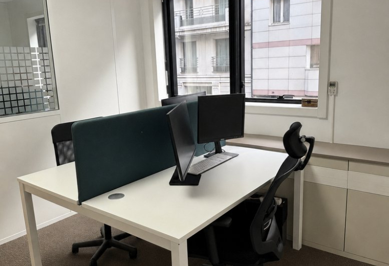 Workspace at 48, Rue Victor Hugo featuring dual desks with privacy screens and ergonomic chairs.