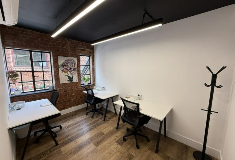 Spacious three-person office suite at 5, Crown Passage with exposed brick walls and industrial lighting.