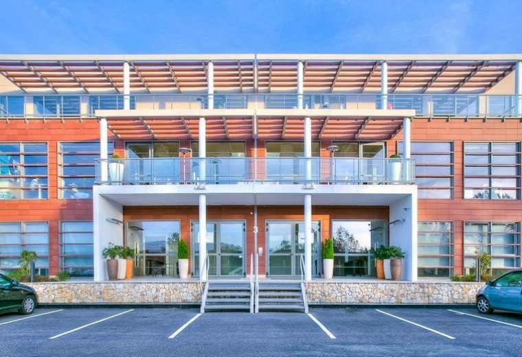Exterior view of the modern brick and glass building at 535, Route des Lucioles.