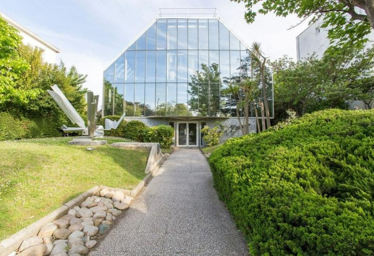 Exterior view of the glass-facade building at 565 Avenue du Prado.