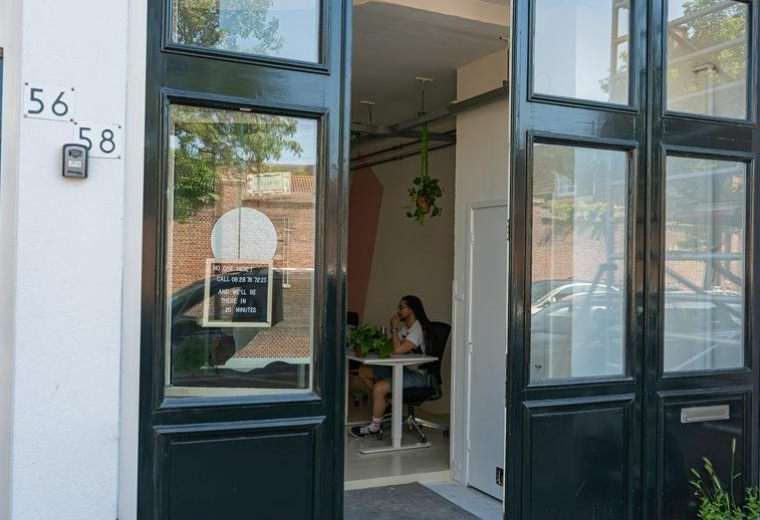 Exterior entrance of 58, Lange Beestenmarkt featuring large black industrial glass doors and street numbering.