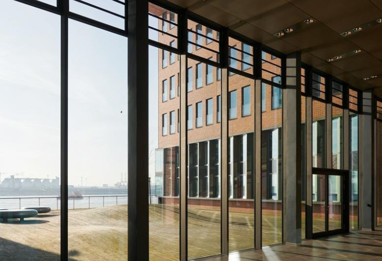 Spacious modern lobby of the building at 59, Große Elbstraße with large glass walls and waterfront views.