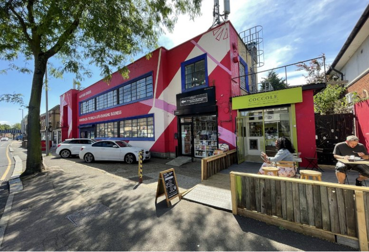 Exterior view of the colorful red and white building facade at 679, High Road Leyton.