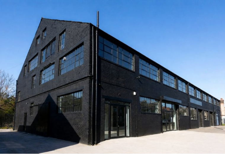 Exterior view of the black gabled warehouse building at 70 Norlington Road.