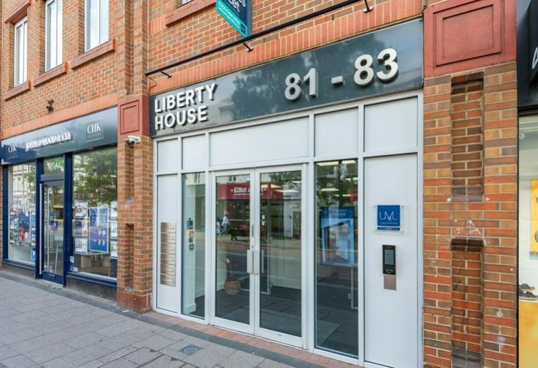 Street level view of the glass entrance and brick facade at Liberty House.