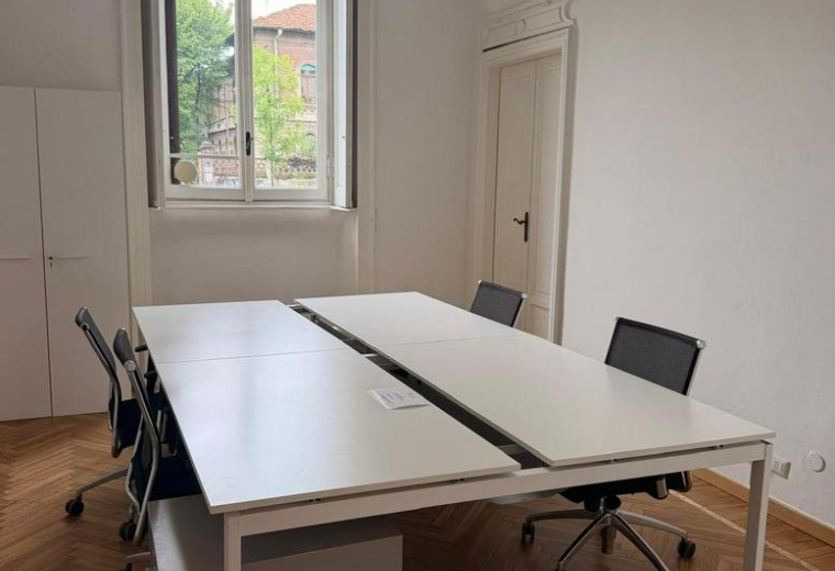 Professional four-person office suite at 9, Corso Plebisciti with herringbone wood floors and high ceilings.