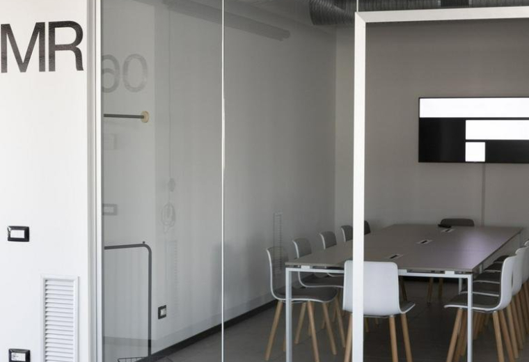 Meeting room with glass walls and large table at 93, Via Nazionale.
