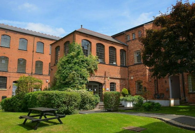 Exterior view of Bradford Court Business Centre with brick facade and greenery.