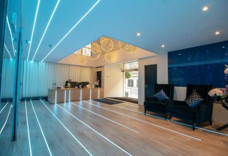 Sleek modern reception at Dawson House with illuminated floor strips and blue neon ceiling lights.