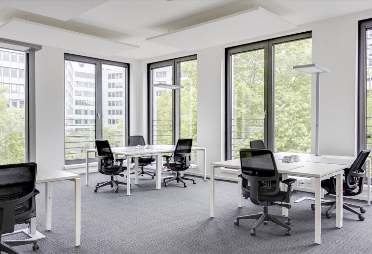 Bright open-plan office space at Groat House, 20 Collingwood Street with white desks and large windows.