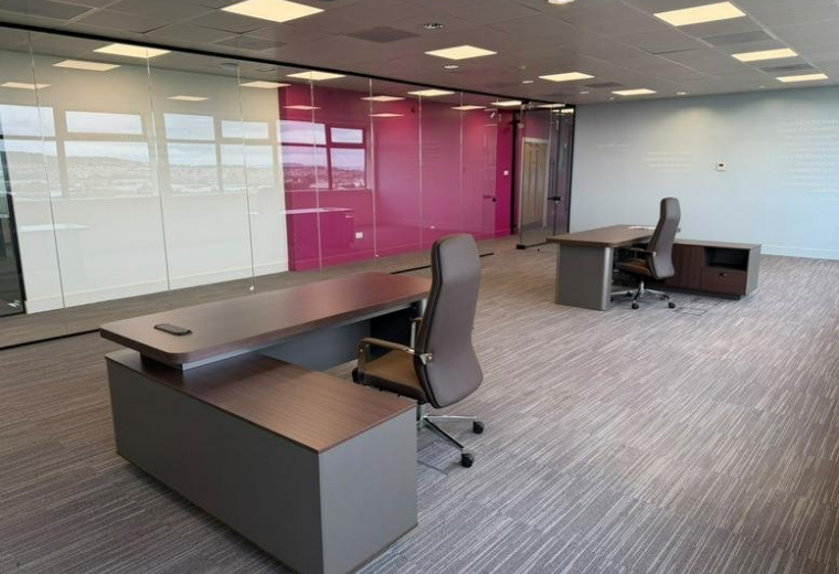Spacious private office at Hermiston Quay, 5, Cultins Road with modern desks and a vibrant pink feature wall.