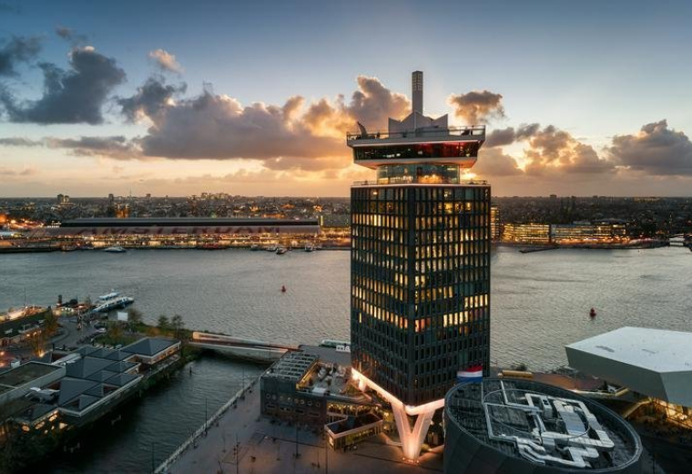 Exterior view of the landmark A'DAM Tower at Overhoeksplein 1, 1031KS Amsterdam during sunset.