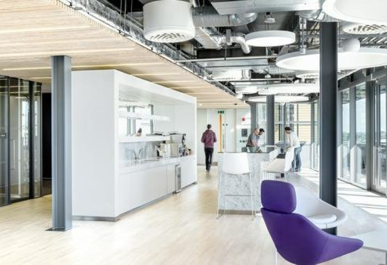 Spacious open-plan lounge area with purple chairs and floor-to-ceiling windows at Point Square Offices.