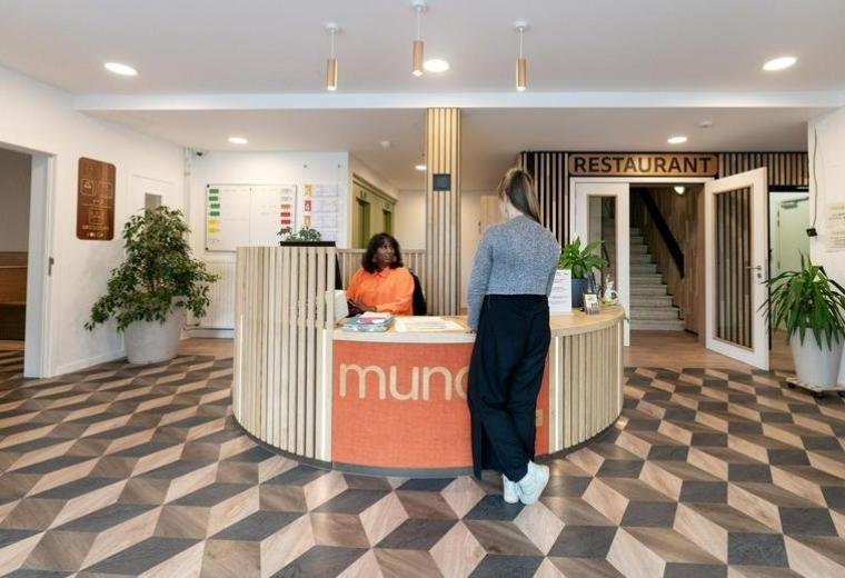 Reception area at Rue Nanon featuring a curved desk and patterned floor.