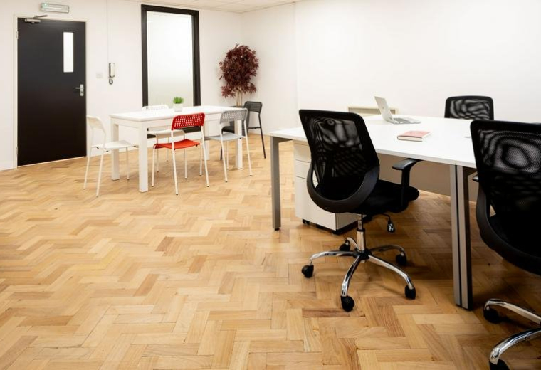 Spacious open-plan office with parquet flooring and several workstations at Steward House.