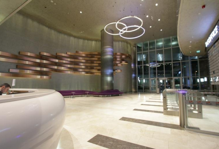 Spacious reception lobby featuring a curved white desk and modern ring pendant lighting.