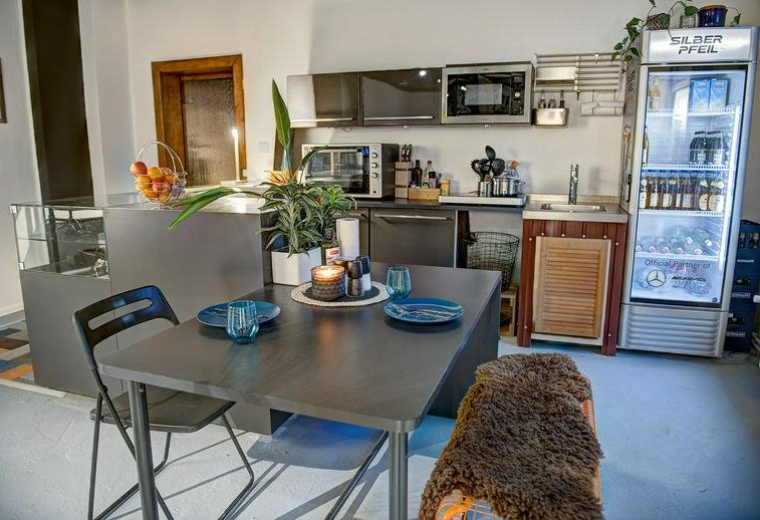 Kitchen and dining area at Provinzstrasse 57, Berlin, Brandenburg with a table and glass-door refrigerator.