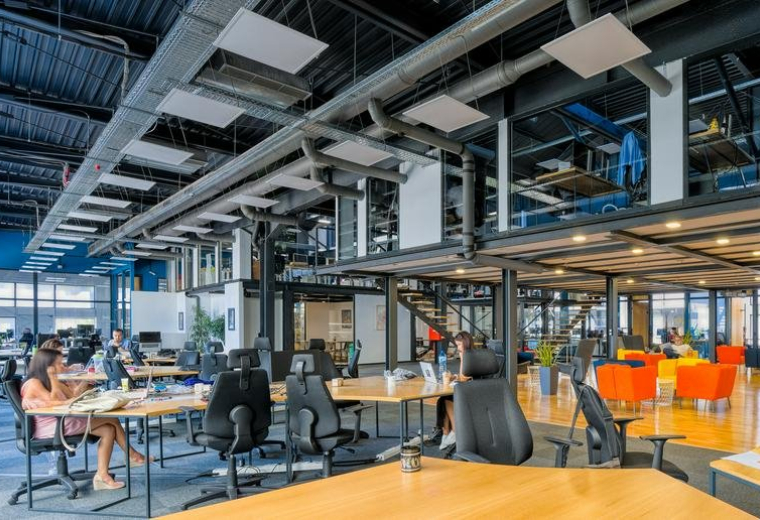 Industrial-style open workspace with exposed ceiling and mezzanine at Tintyava 15-17, Sofia, Bulgaria.