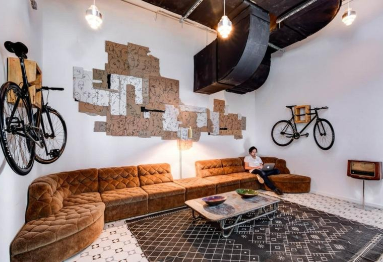 Spacious communal lounge at Uhlandstraße 32, Berlin, Brandenburg featuring a velvet sofa and bicycle wall mounts.