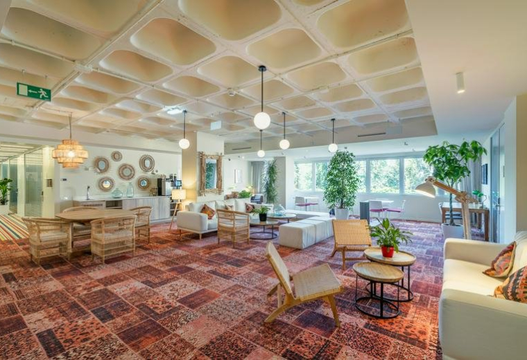 Spacious communal lounge at Utopicus José Abascal featuring a unique coffered ceiling and eclectic patterned carpet.