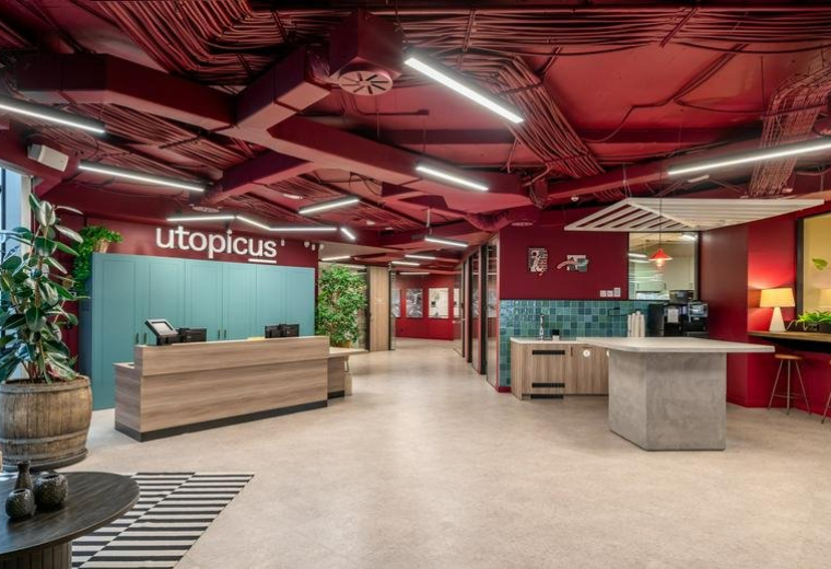 Spacious reception area with a wooden desk and bold red ceiling at Utopicus Príncipe de Vergara.
