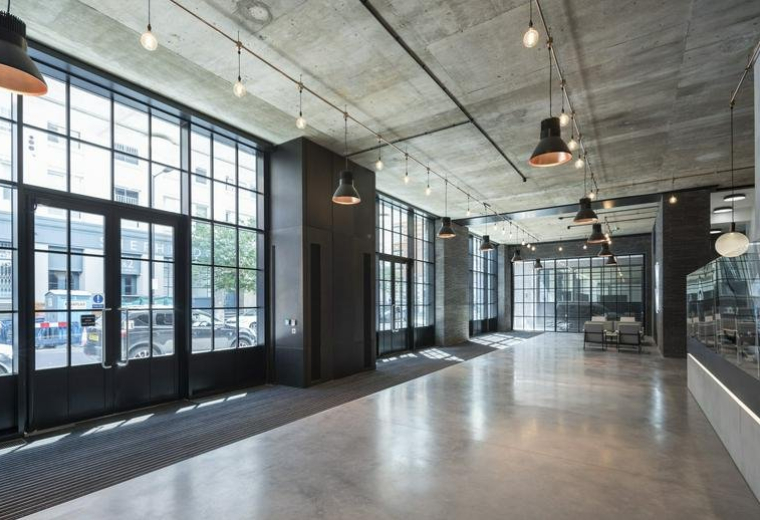 Industrial style lobby with polished concrete floors and large gridded windows.