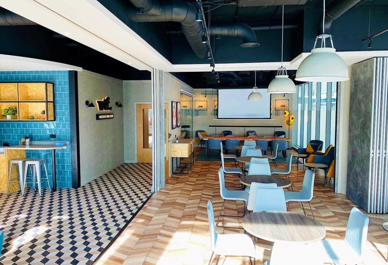 Spacious communal lounge and coworking area at 5 Cavell Street with checkered and wood flooring.