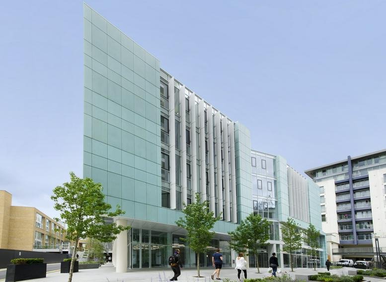 Contemporary glass facade of the main building with landscaped entrance.