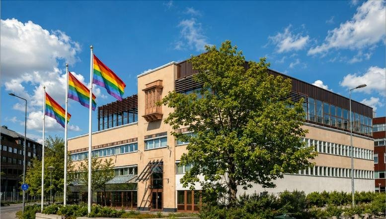 Exterior view of the tan brick building at 1, Malmvägen with pride flags flying out front.
