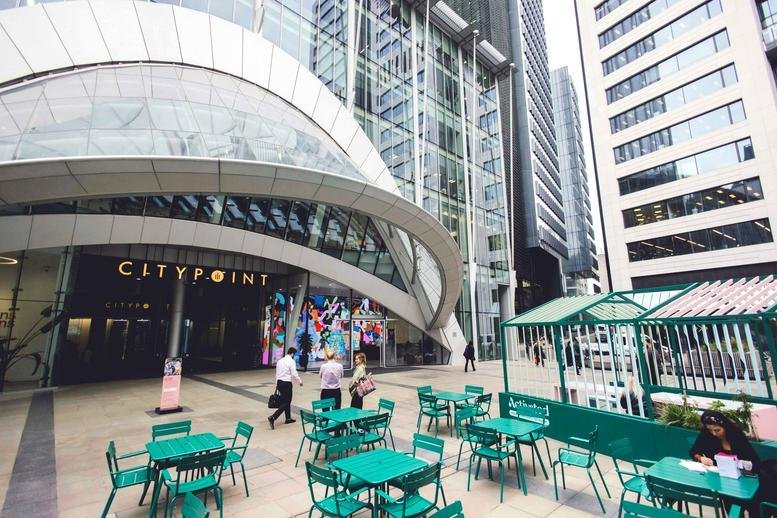 Exterior view of the glass-facade 1, Ropemaker Street building with outdoor cafe seating.