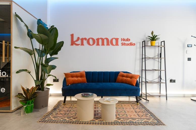 Spacious reception area at 10, Carrer dels Tarongers, with a blue velvet sofa, large plants, and warm lighting.