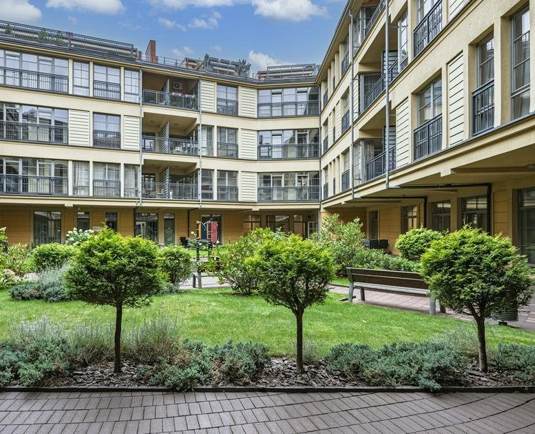 Exterior view of the landscaped courtyard and modern facade at 10, Šiaulių gatvė, in Vilnius.