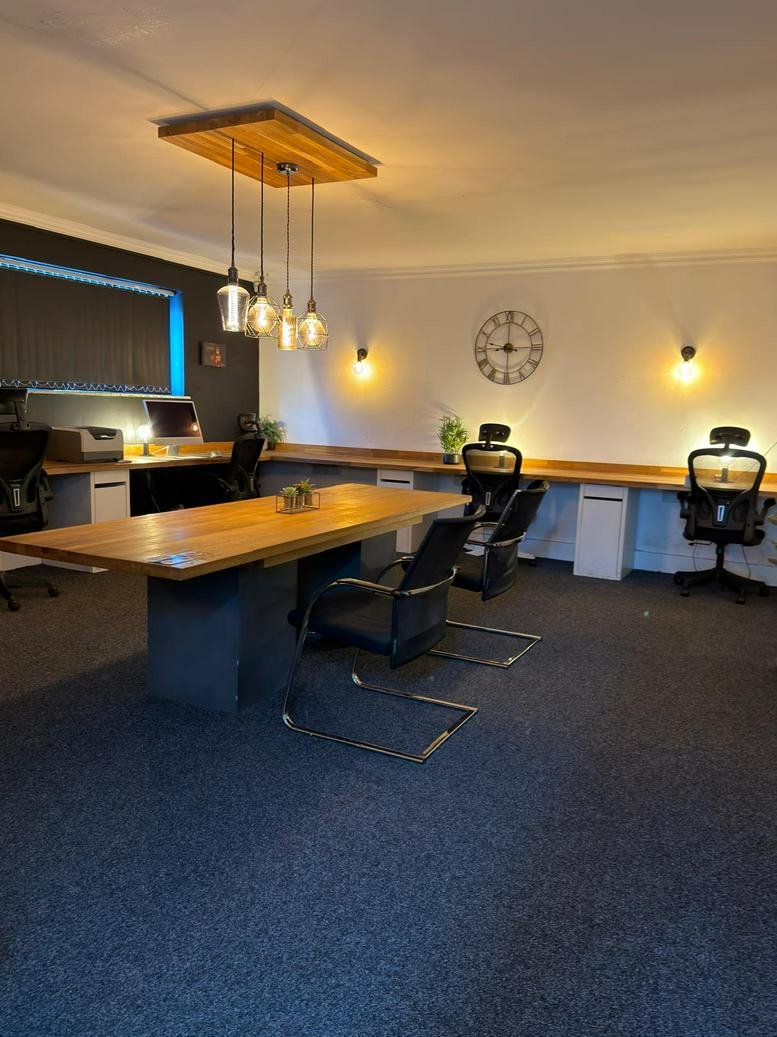 Spacious co-working office at 10, Sampson Road North with warm pendant lighting and wooden desks.