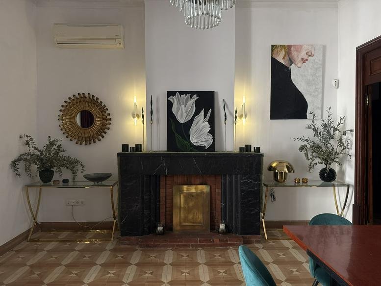 Grand communal room with a black marble fireplace and gold accents.